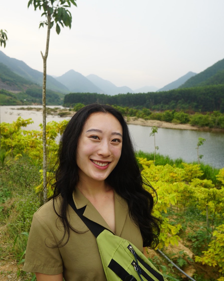 Portrait of Valerie Chen smiling outdoors by a river and mountains